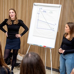 Bilde av NHH-studentene Hanna Notland og Maren Huseth Mortensen som presenterer oppgave. Foto: Helge Skodvin