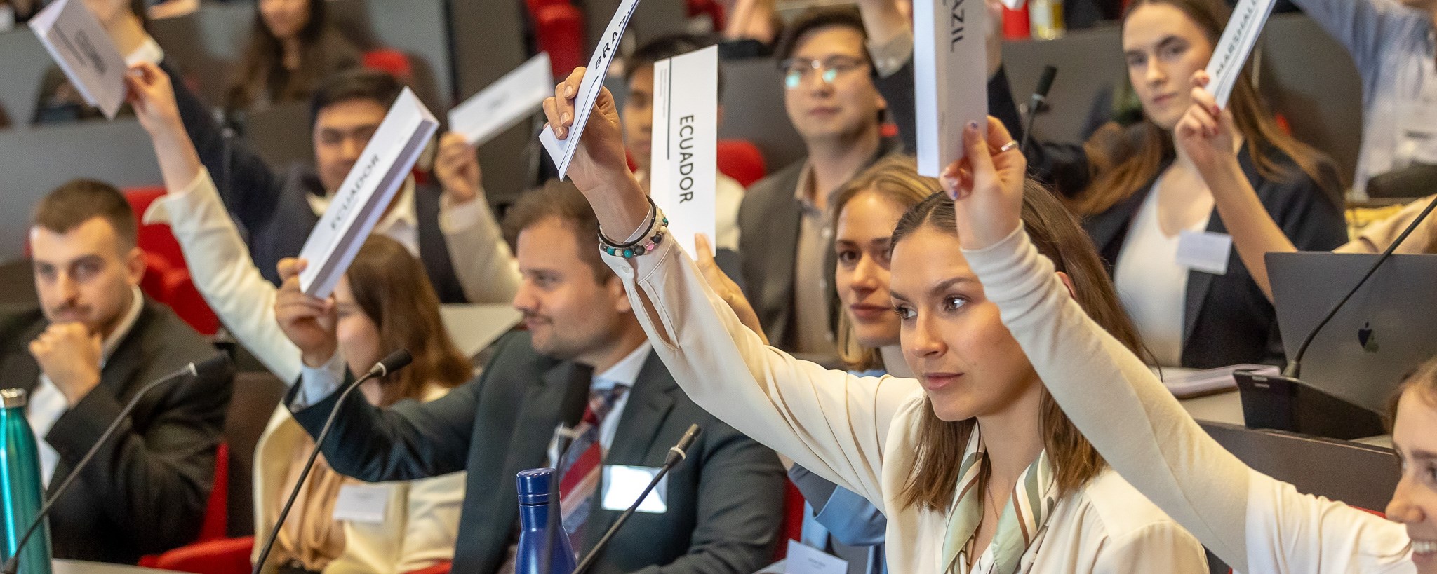 Students voting during Model UN, lifting up the paper naming their country
