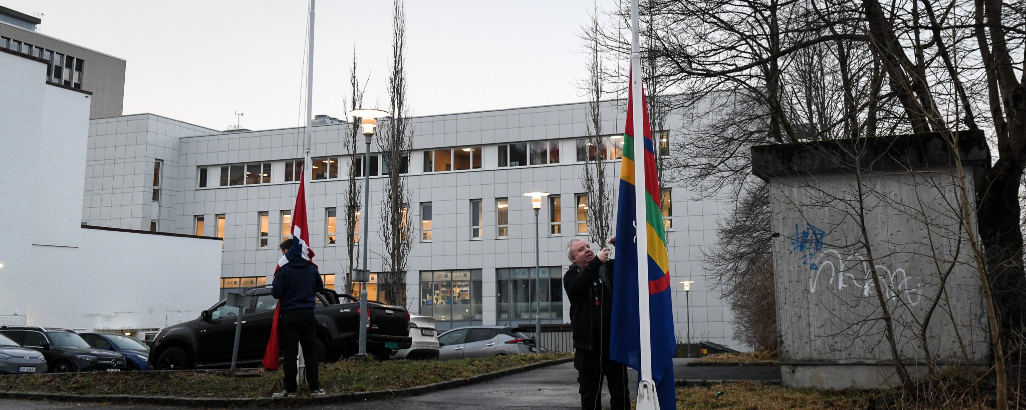 Two persons hoisting the flags