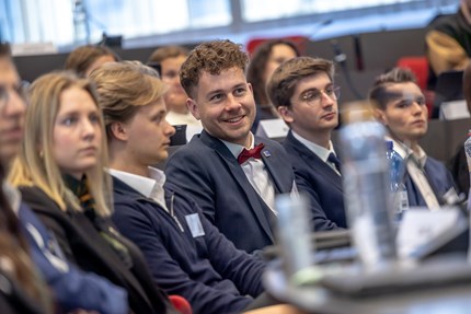 Student with bow tie sitting in the audience