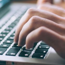 Bildet viser hender på et laptop-tastatur