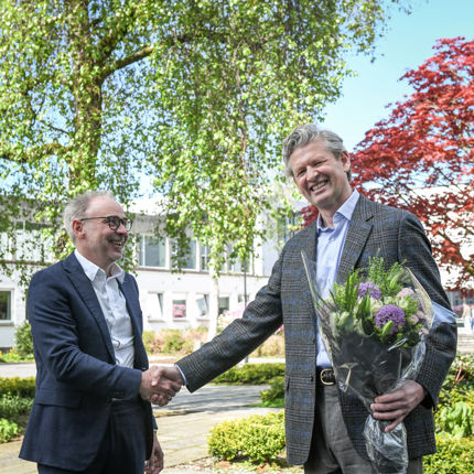 NHH-rektor overrekker blomster til den nye professoren, Øyvind Thomassen. 