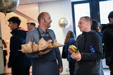 Stig handing out burgers to students
