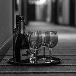 A tray with an empty bottle and a few empty glasses.