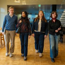 Four students walk together through a bright corridor at Hanken School of Economics in Helsinki.