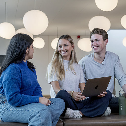 Bilde av tre NHH-studenter som snakker sammen. Foto: Helge Skodvin