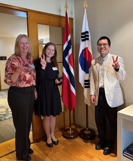 The three NHH employees in front of the Norwegian and Sout Korean flags