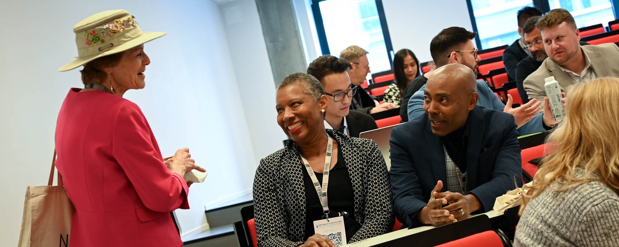 Three conference participants talking to each other in the auditorium