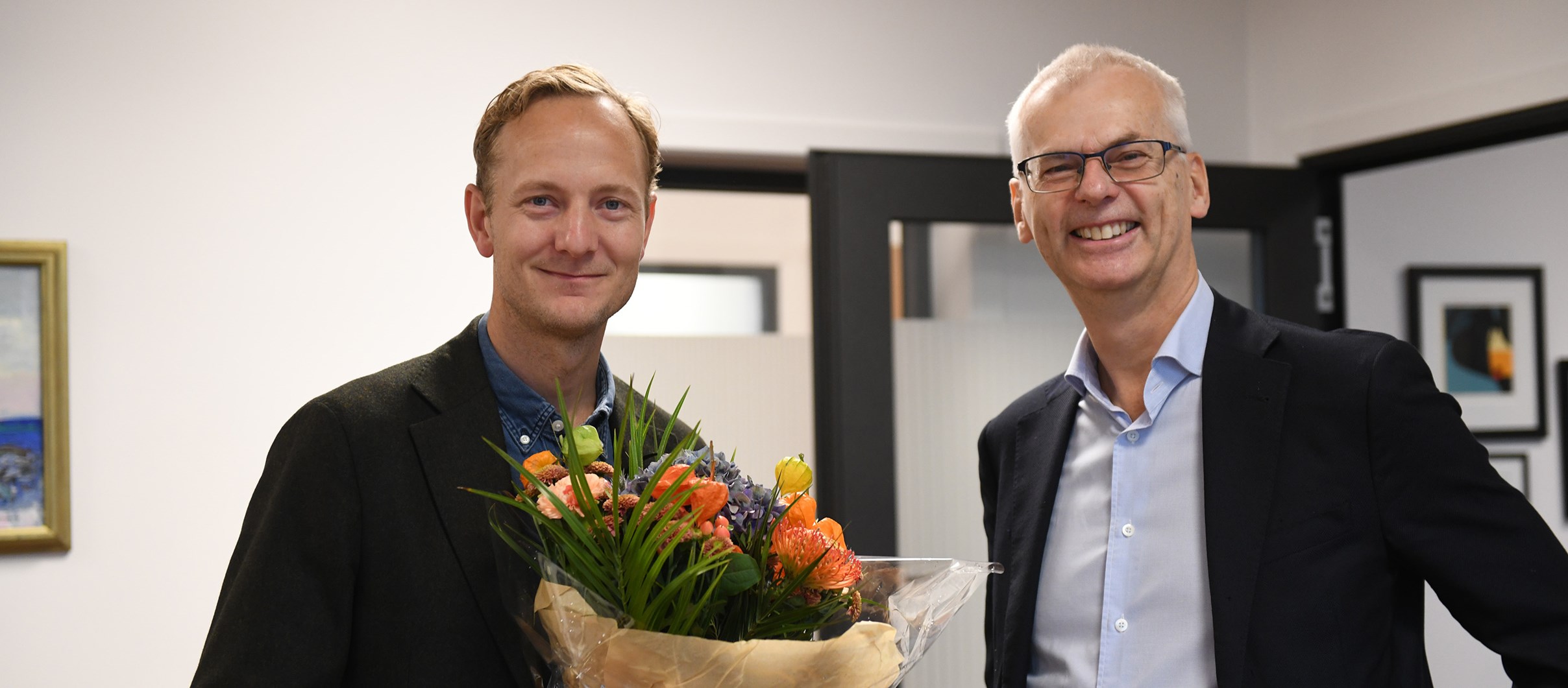 Mathias Ekström blir gratulert av NHHs rektor Øystein Thøgersen.