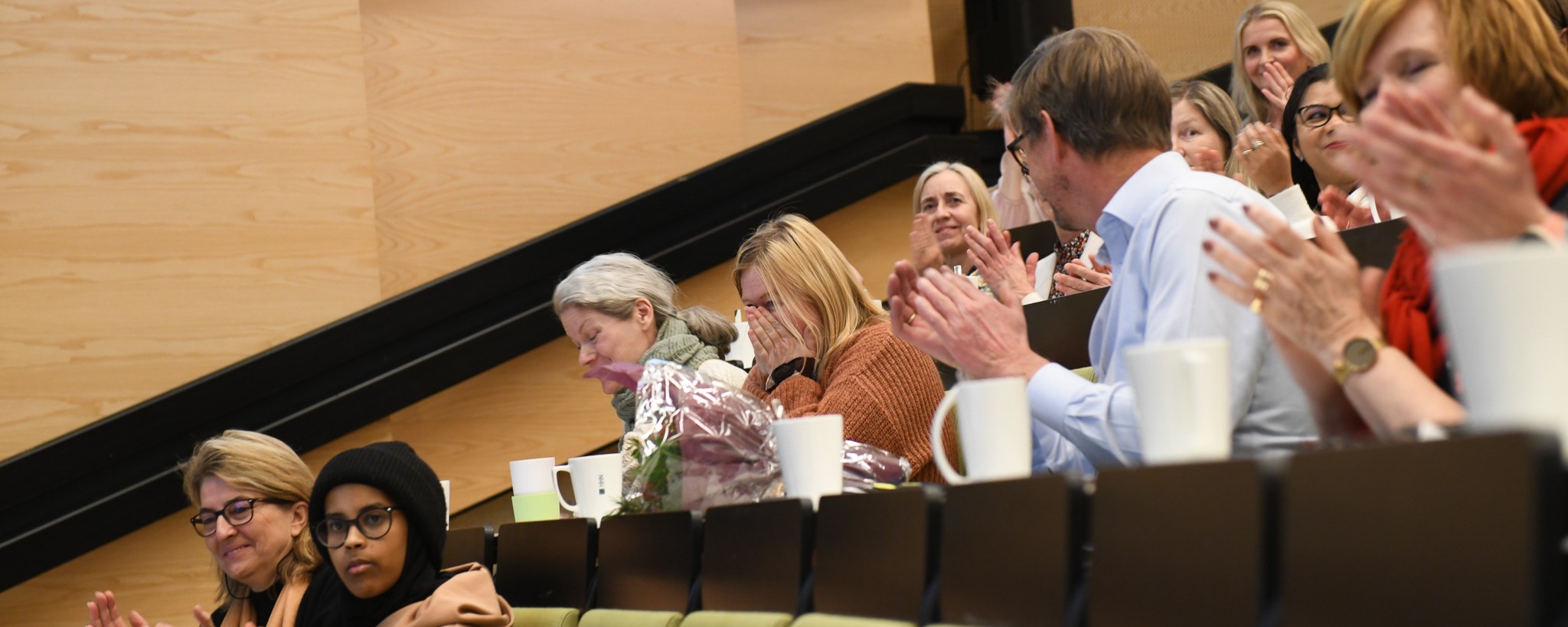 Audience clapping, surprised award winner.