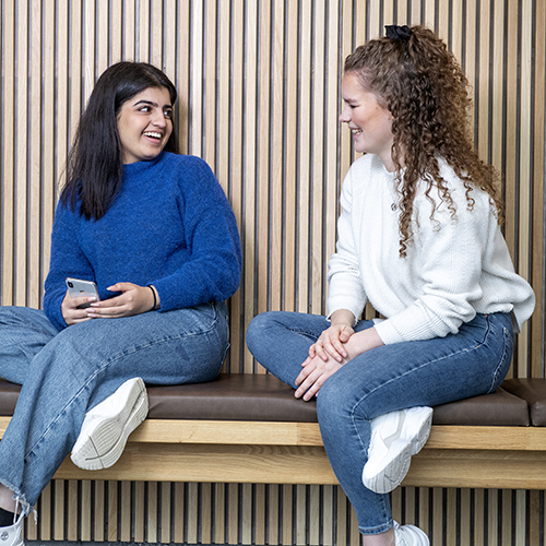 Bilde av to kvinnelige NHH-studenter som smiler. Foto: Helge Skodvin