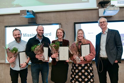 Group photo with flowers and diplomas.