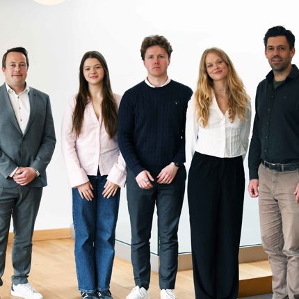 A photo of five people, three men and two women, posed for a group picture.
