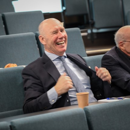 Tor sitting in the audience smiling during his celebratory seminar