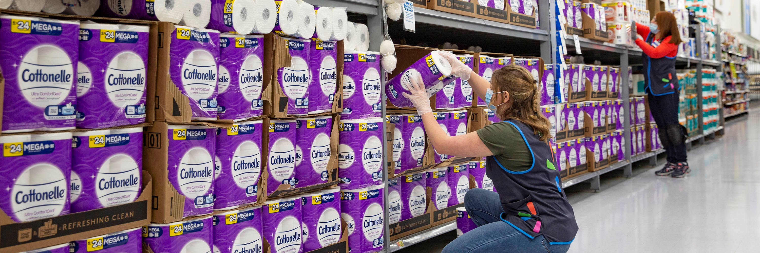 Walmart associates restock toilet paper. Walmart press photo