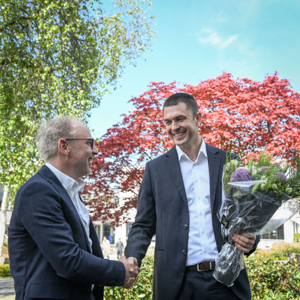 Håkon Otneim blir gratulert av NHHs professor Helge Thorbjørnsen. 