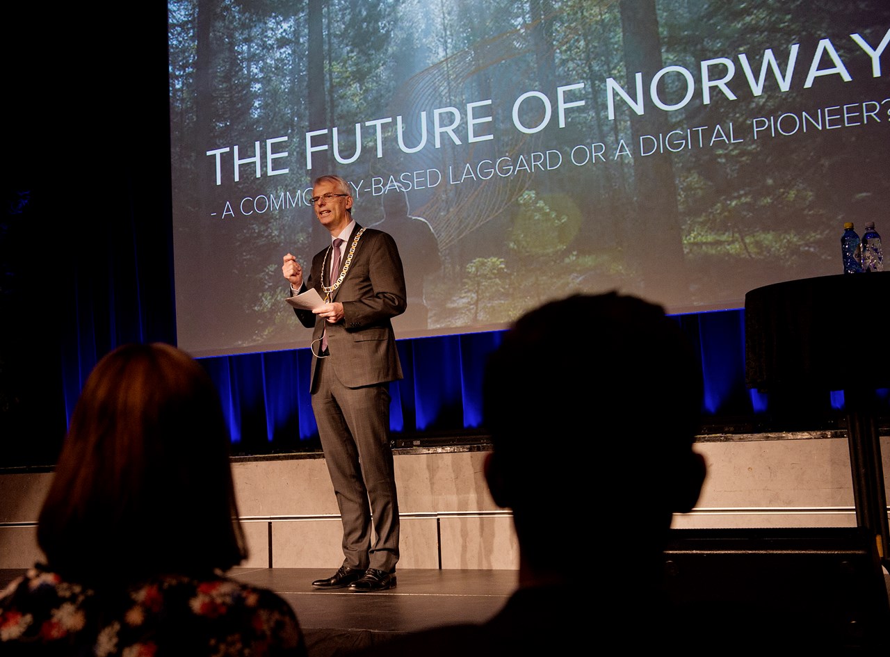 Øystein Thøgersen introduserer årets foreleser til en fullsatt aula på NHH. 