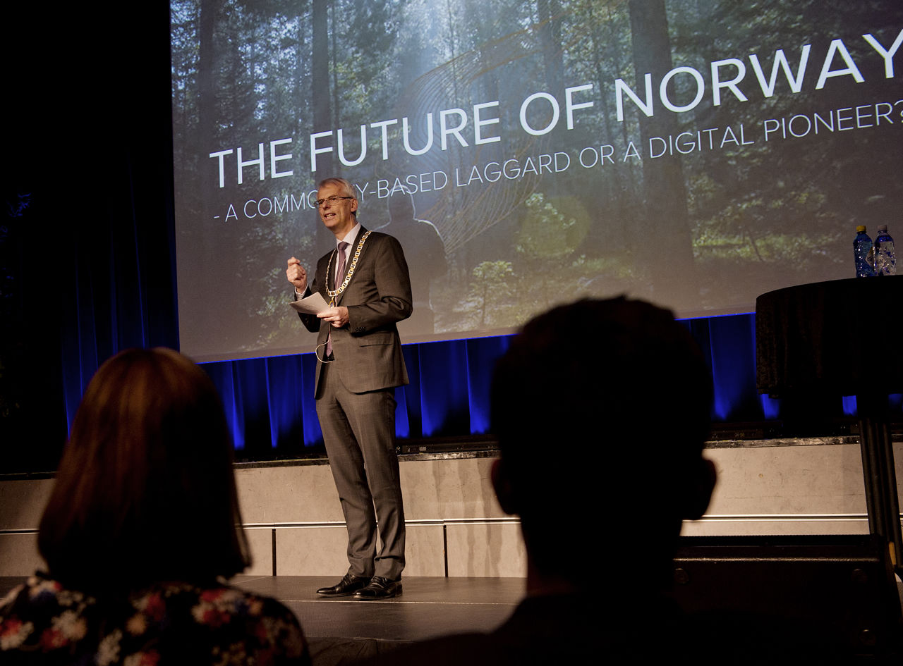 Øystein Thøgersen introduserer årets foreleser til en fullsatt aula på NHH. 